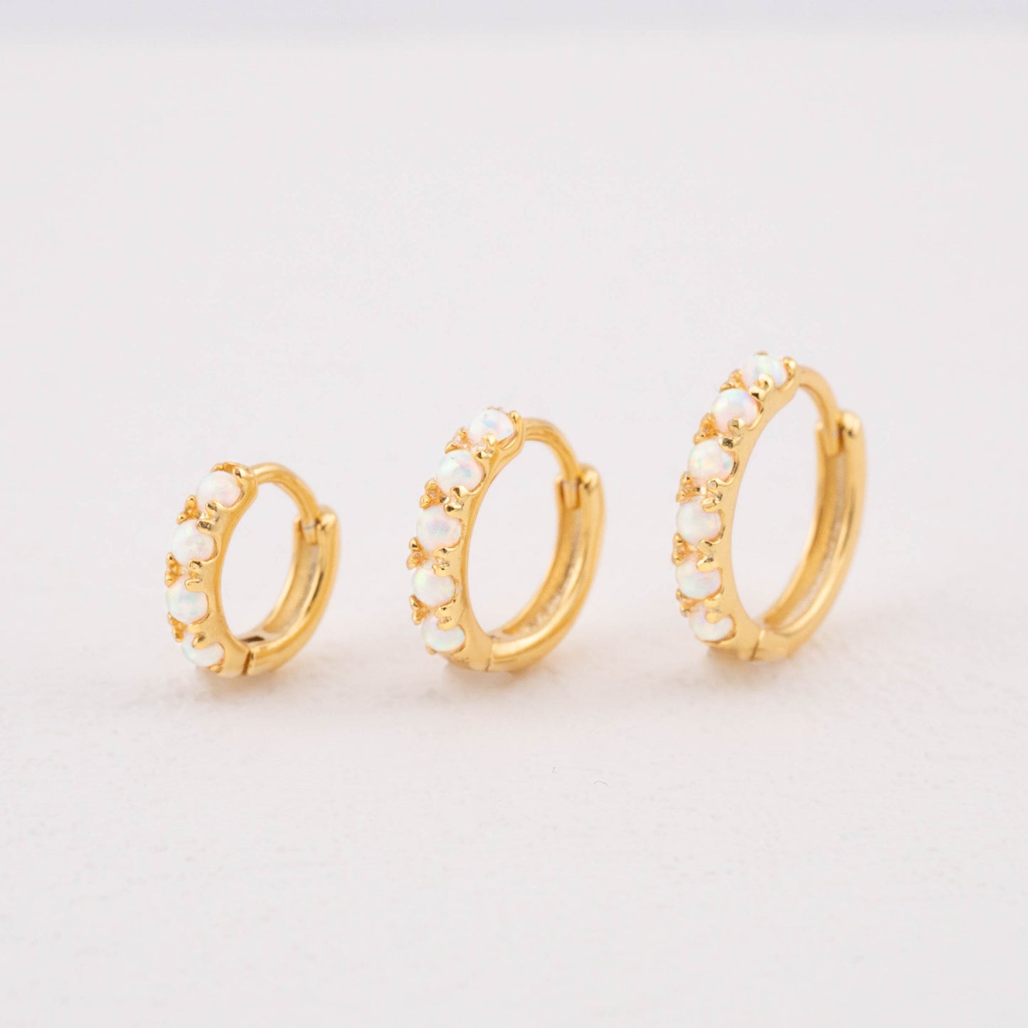 Opalescent earrings in gold, showing 6mm, 8mm, and 10mm white opal sizes.