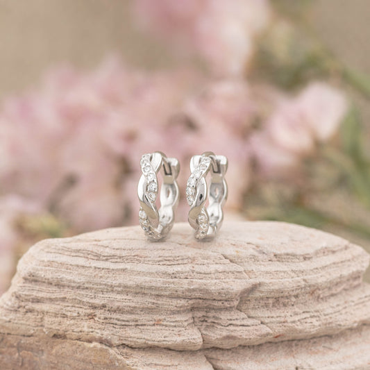 Close-up of twisted 9mm huggie hoop earring in sterling silver, showing the braided design and smooth finish.